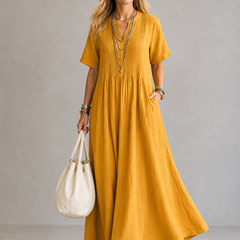 Yellow pleated maxi dress with V-neck and short sleeves, gathered waist.