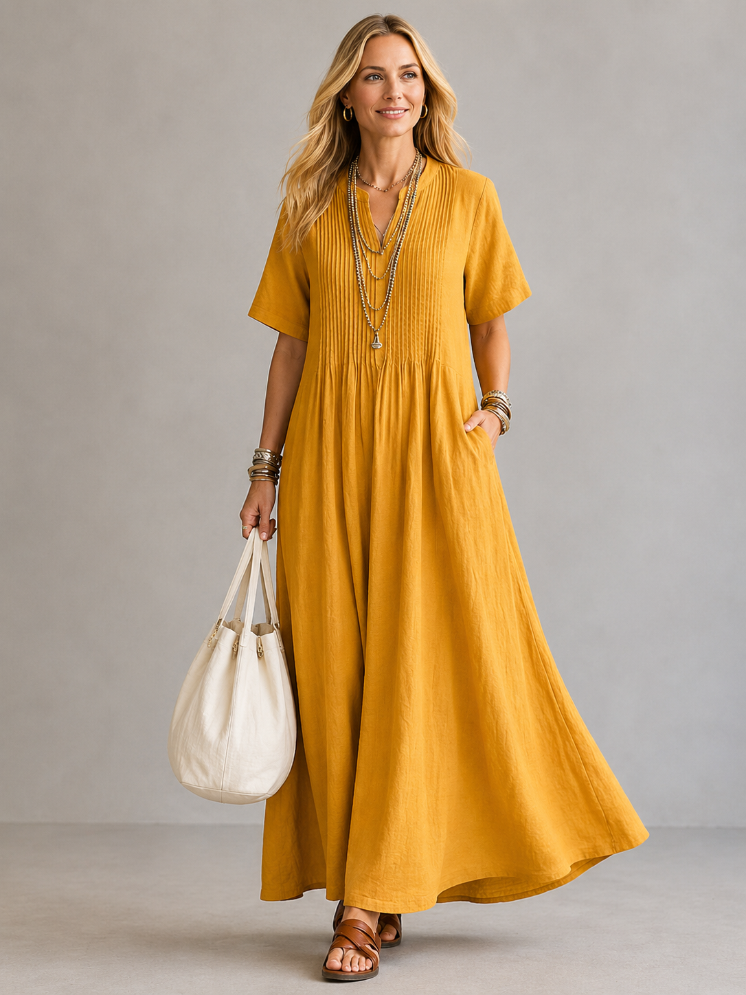 Yellow pleated maxi dress with V-neck and short sleeves, gathered waist.