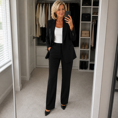 Black tailored suit with blazer and straight trousers, worn over a white top