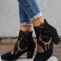 Black orthopedic heeled ankle boots with floral lace cutouts and block heel