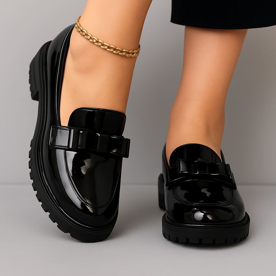Black patent block-heel loafers with glossy finish and buckle detail at the front