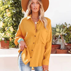 Yellow loose-fitting button-up blouse with collar and chest pocket, front view.