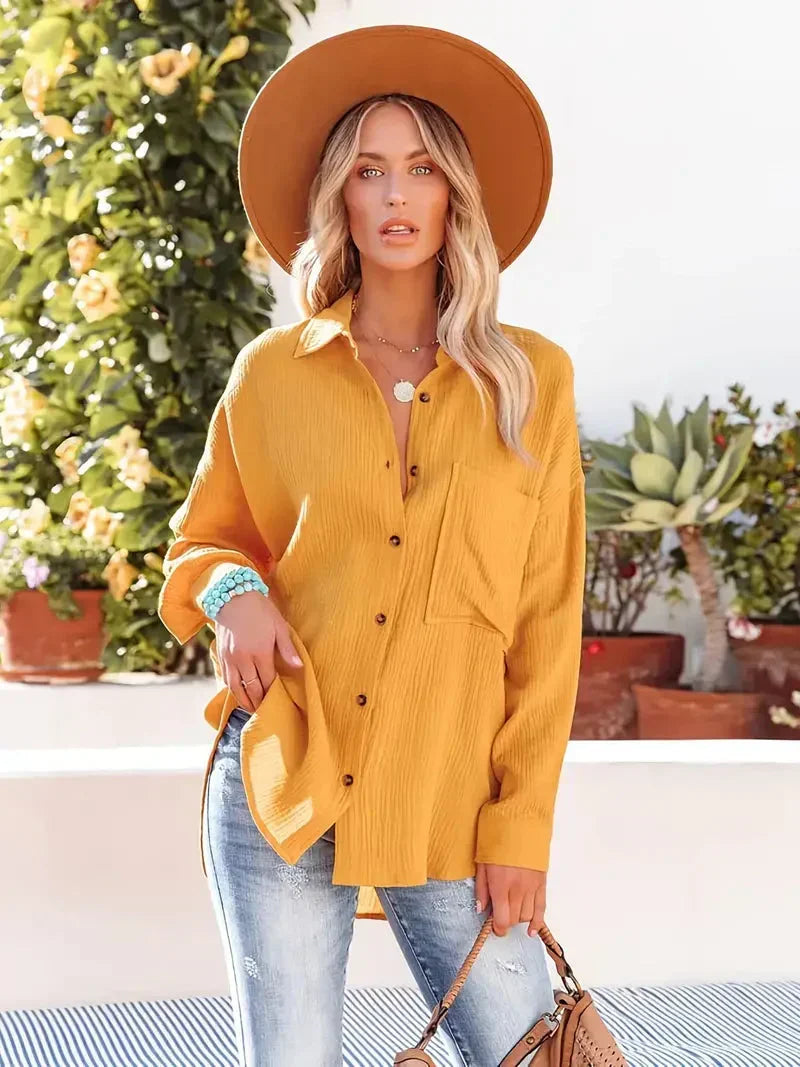 Yellow loose-fitting button-up blouse with collar and chest pocket, front view.