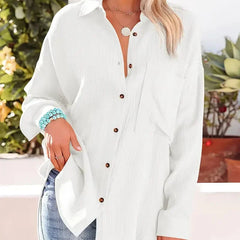 White loose-fitting button-up blouse with collar and long sleeves, front view.