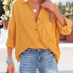Yellow loose-fitting button-up blouse with collar, long sleeves, and chest pocket.