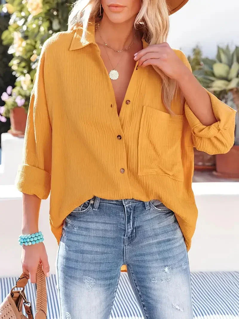 Yellow loose-fitting button-up blouse with collar, long sleeves, and chest pocket.