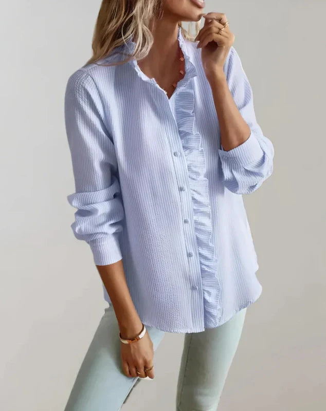 Light blue blouse with ruffle trim at front and buttoned placket, long sleeves