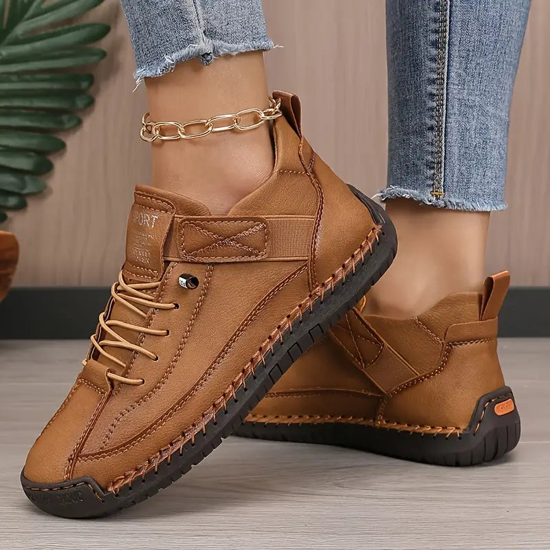 Brown comfort sneakers with lace-up front, padded collar, and chain ankle strap