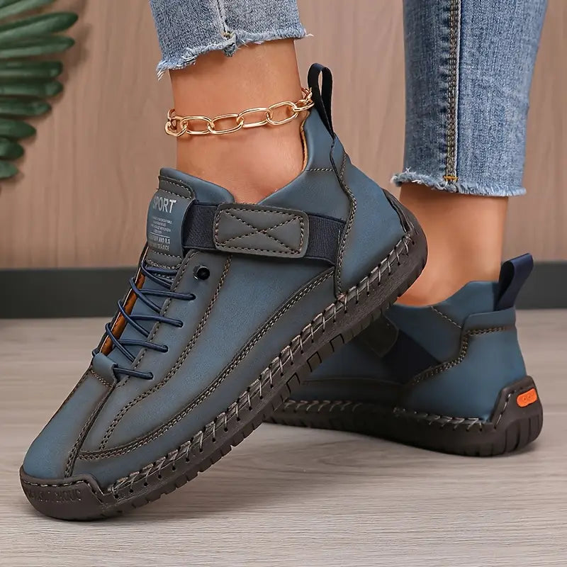 Blue comfort sneakers with lace-up front, ankle strap, and chain ankle detail