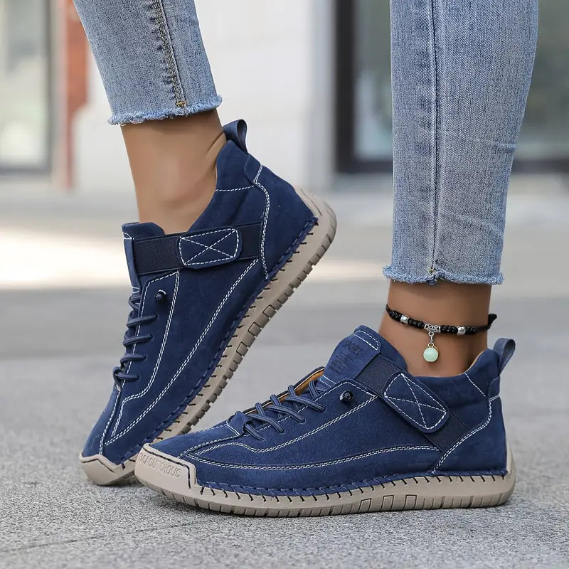 Navy blue comfort sneakers with lace-up front, padded collar, and chain ankle strap