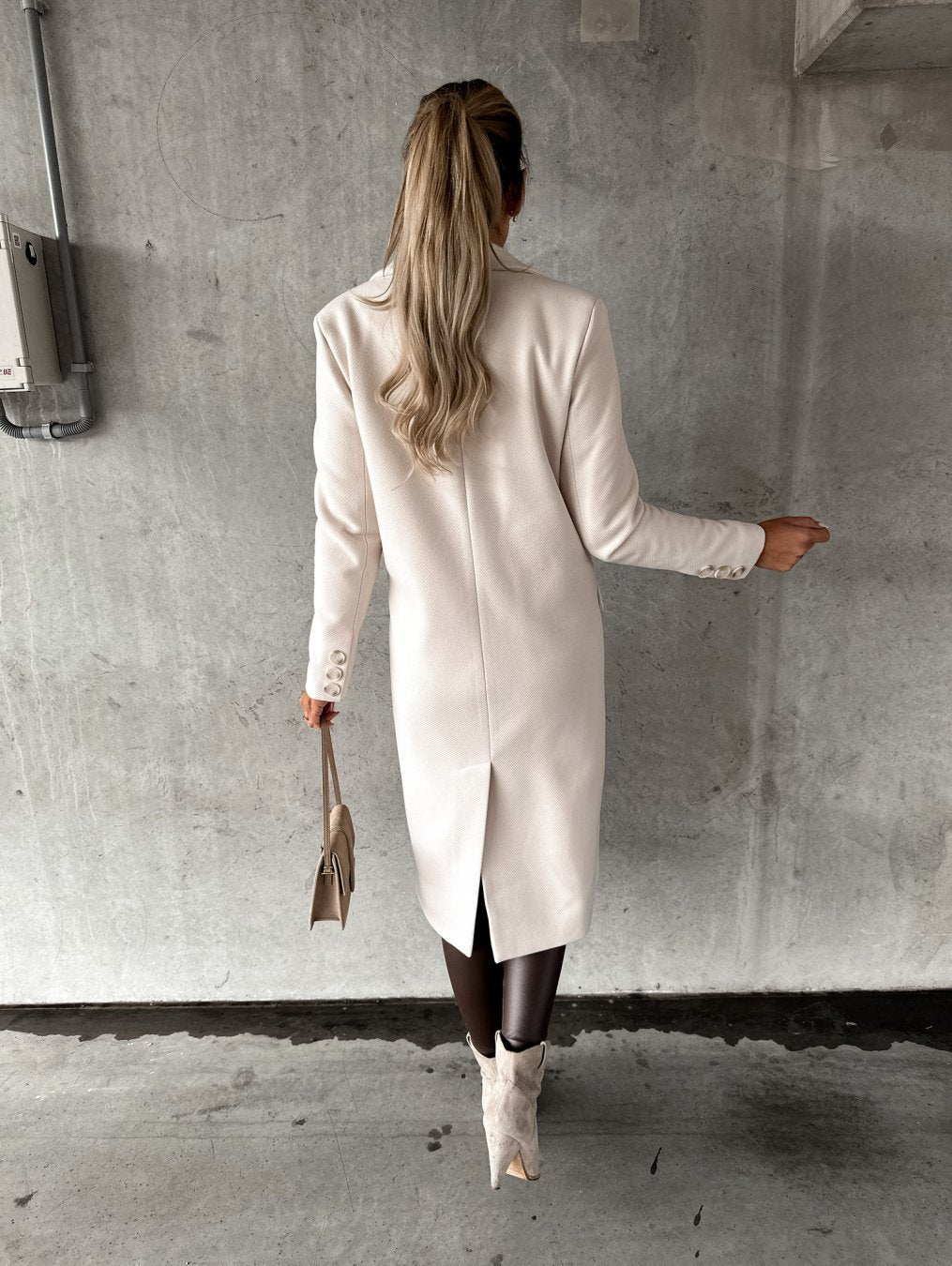 Cream long coat back view with long sleeves and center seam