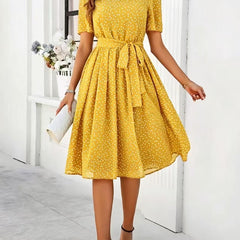 Yellow polka-dot dress with short sleeves, tie waist, and flared midi skirt