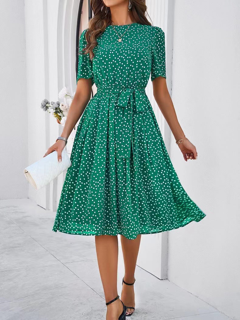 Green polka-dot midi dress with short sleeves, gathered waist, and full skirt