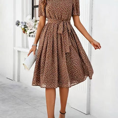 Brown polka-dot dress with short sleeves, tie waist, and flared midi skirt