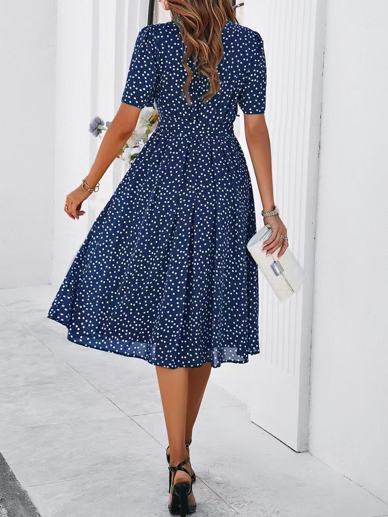 Navy polka-dot dress with short sleeves, tie waist, and flared midi skirt (side view)