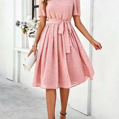 Pink polka-dot dress with short sleeves, tie waist, and flared midi skirt