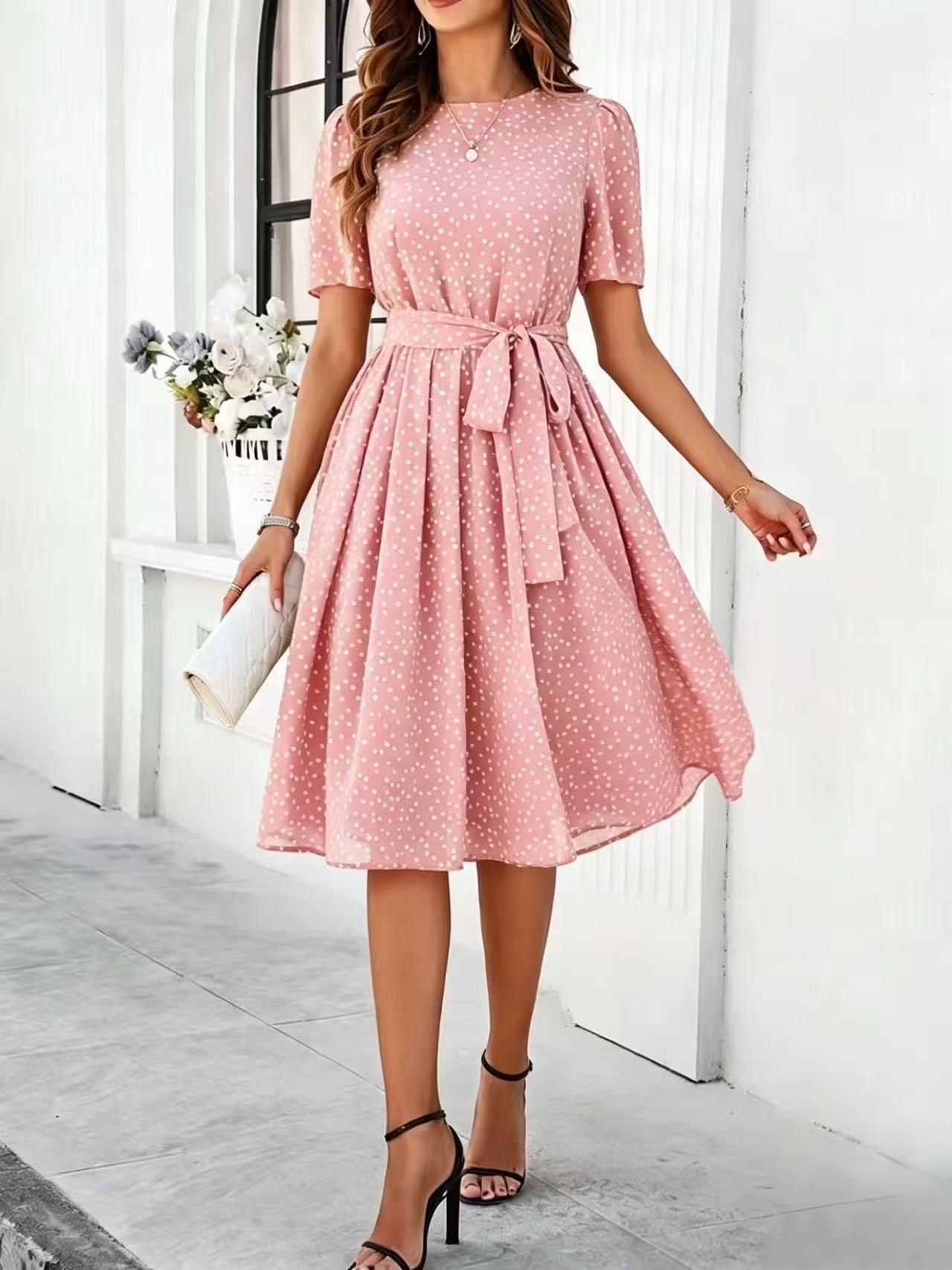 Pink polka-dot dress with short sleeves, tie waist, and flared midi skirt
