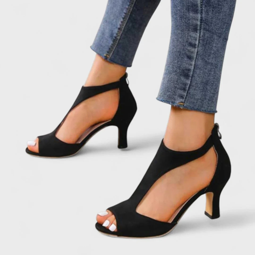 Black heeled sandals with peep toe, ankle strap, and slender heel