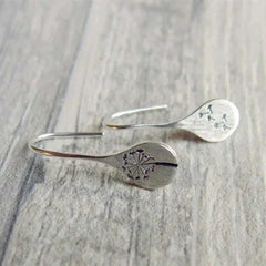 Silver teardrop dangle earrings with engraved dandelion center and thin metal hooks