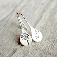 Silver teardrop dangle earrings with engraved dandelion line art, leaf and stem accents