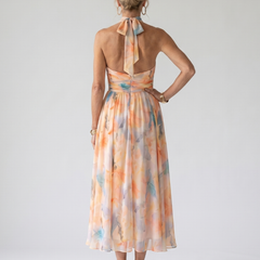 Back view: watercolor orange-and-blue halter midi dress with open back and gathered waist