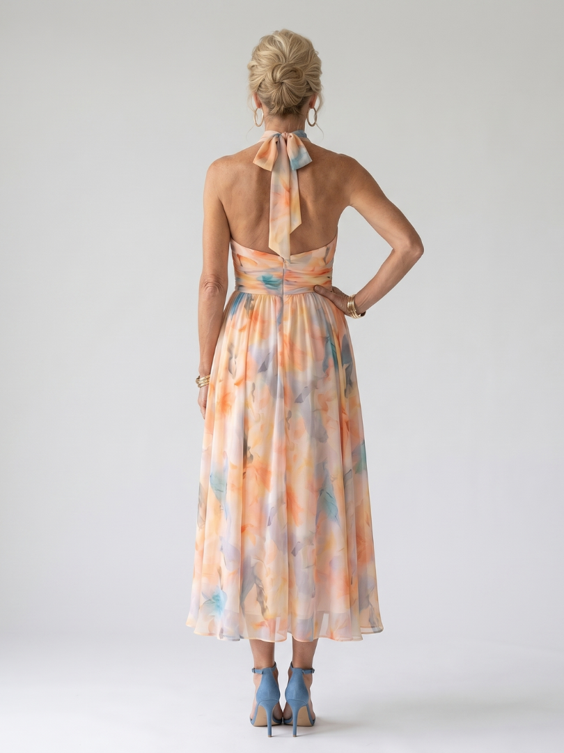 Back view: watercolor orange-and-blue halter midi dress with open back and gathered waist