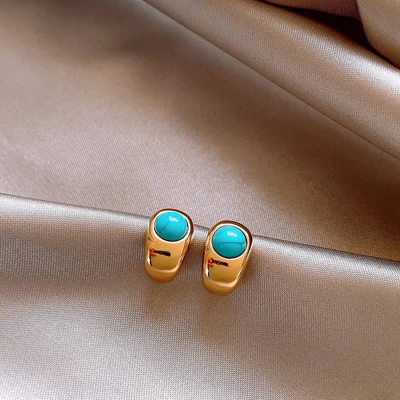 Gold-tone hoop earrings with turquoise round cabochons and hinged back