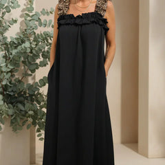 Onyx black flowing maxi dress with ruffled shoulder straps and gathered neckline.