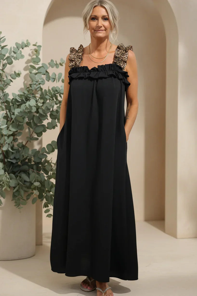 Onyx black flowing maxi dress with ruffled shoulder straps and gathered neckline.