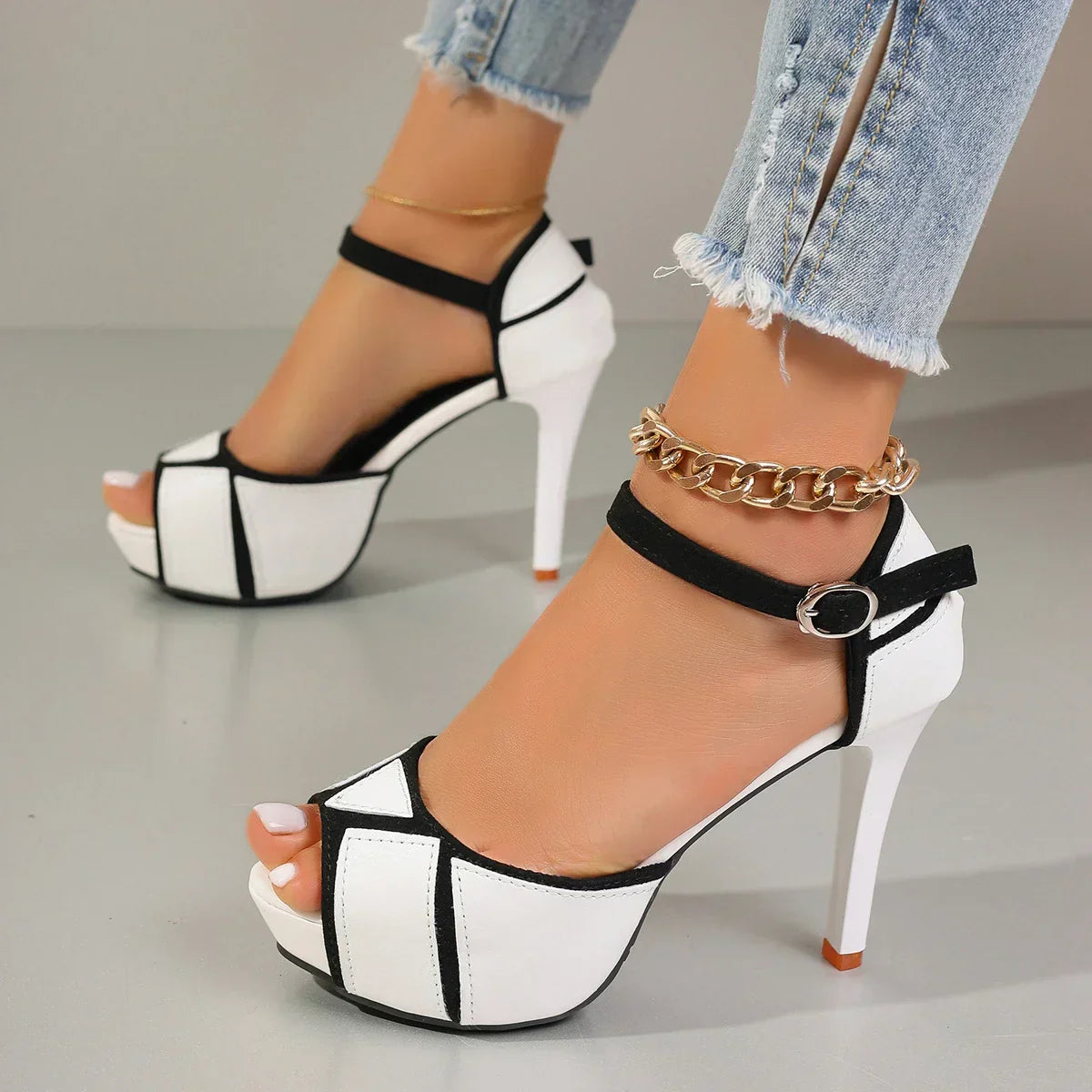Two-tone white and black platform heels with ankle strap and peep-toe