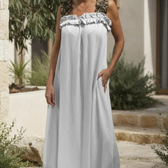 Ivory white flowing maxi dress with ruffled neckline and sleeveless gathered bodice.
