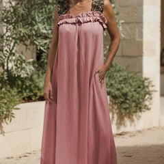 Soft pink flowing maxi dress with ruffled neckline and sleeveless gathered bodice.