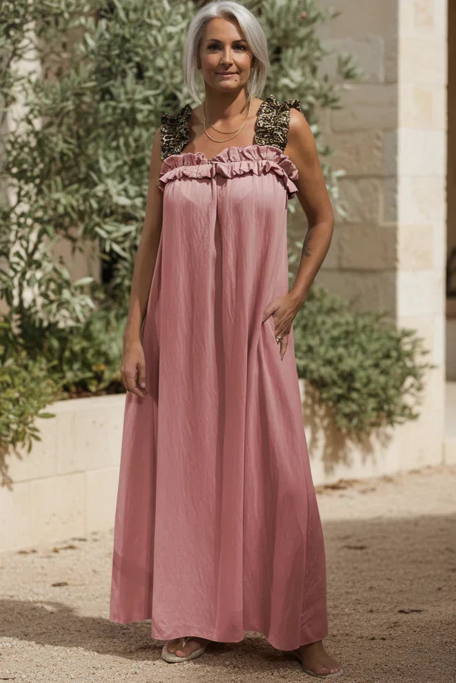 Soft pink flowing maxi dress with ruffled neckline and sleeveless gathered bodice.