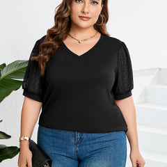 Black sheer-sleeve V-neck top with short puff sleeves, worn with jeans.