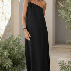 Black relaxed maxi dress with one-shoulder strap and flowing, straight skirt