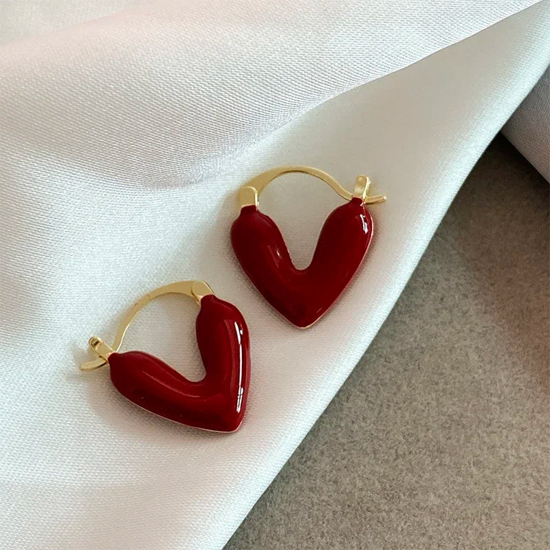 Red heart hoop earrings with gold-tone hooks, glossy heart shape pair.