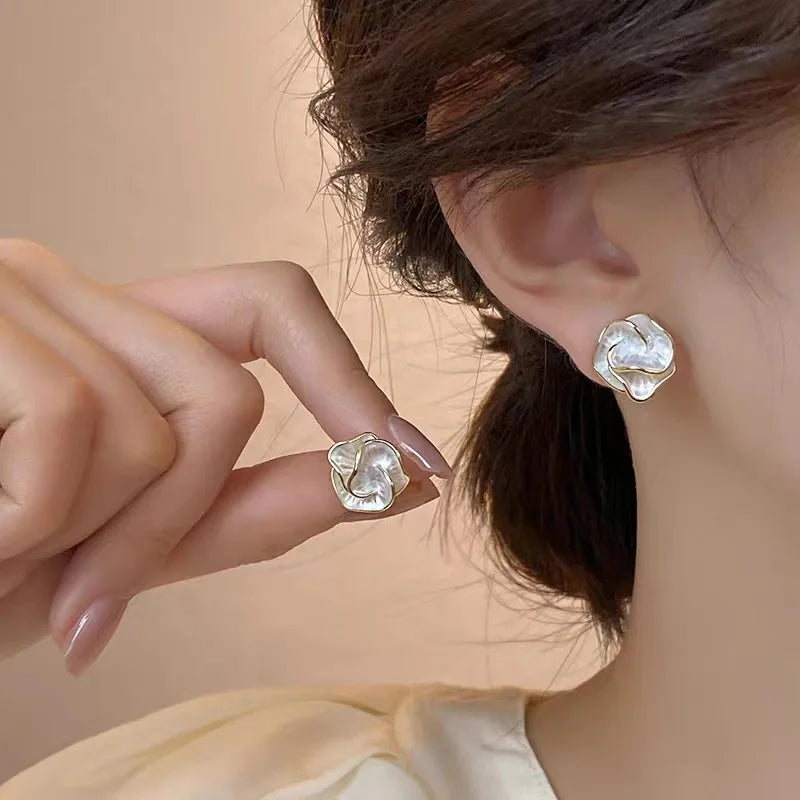 Flower pearl stud earring on model, gold-tone with white petal center