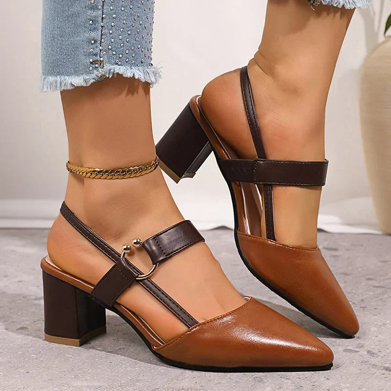 Brown heeled pumps with ring buckle, black straps, and gold ankle chain