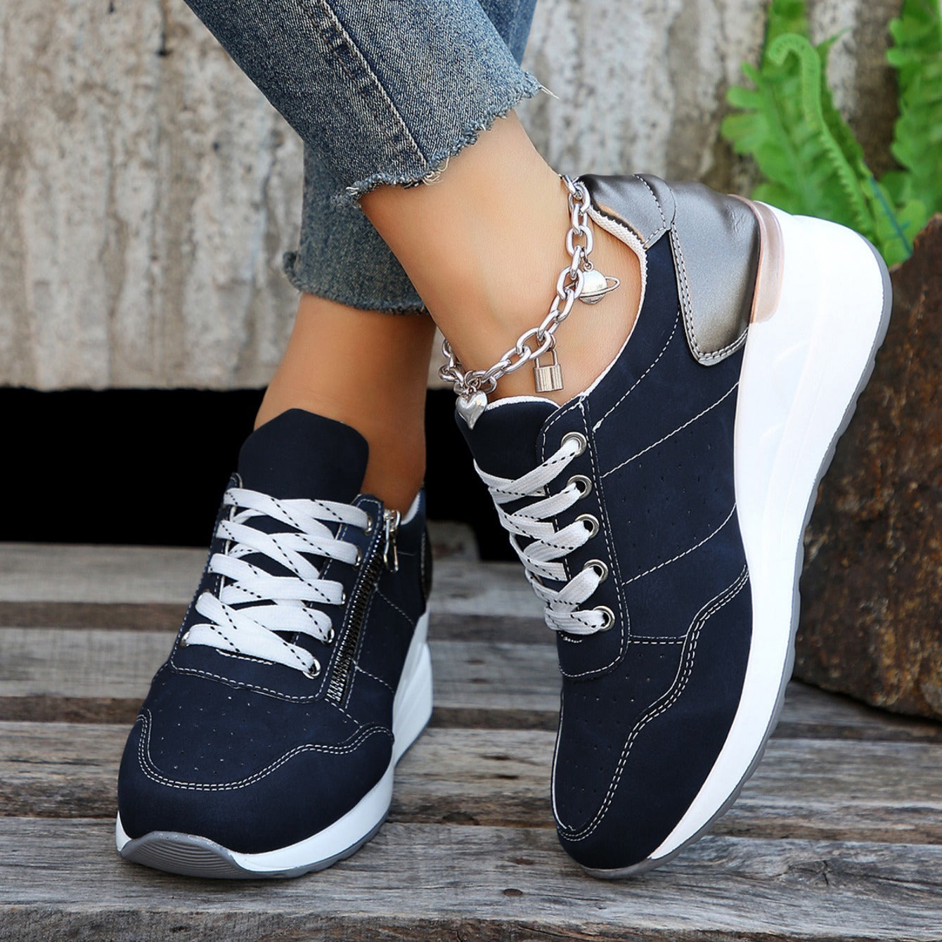 Navy zip-up sneakers with lace-up top, side zipper, white sole, chain strap detail