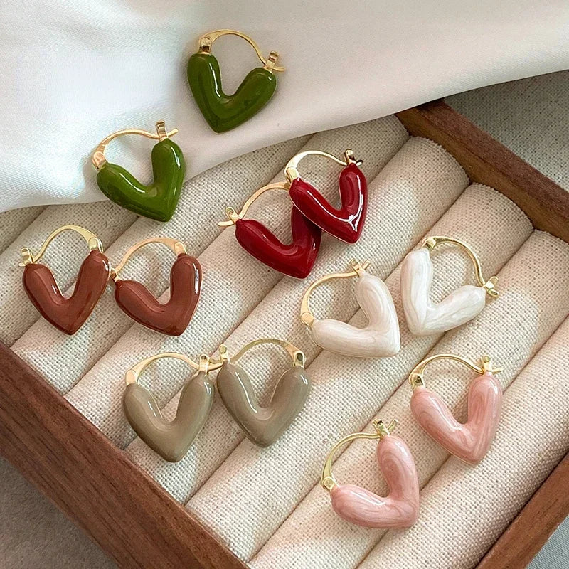 Green heart hoop earrings with gold-tone hooks, glossy sculpted heart design.