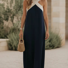 Navy halter maxi dress with ivory crisscross straps and side slit