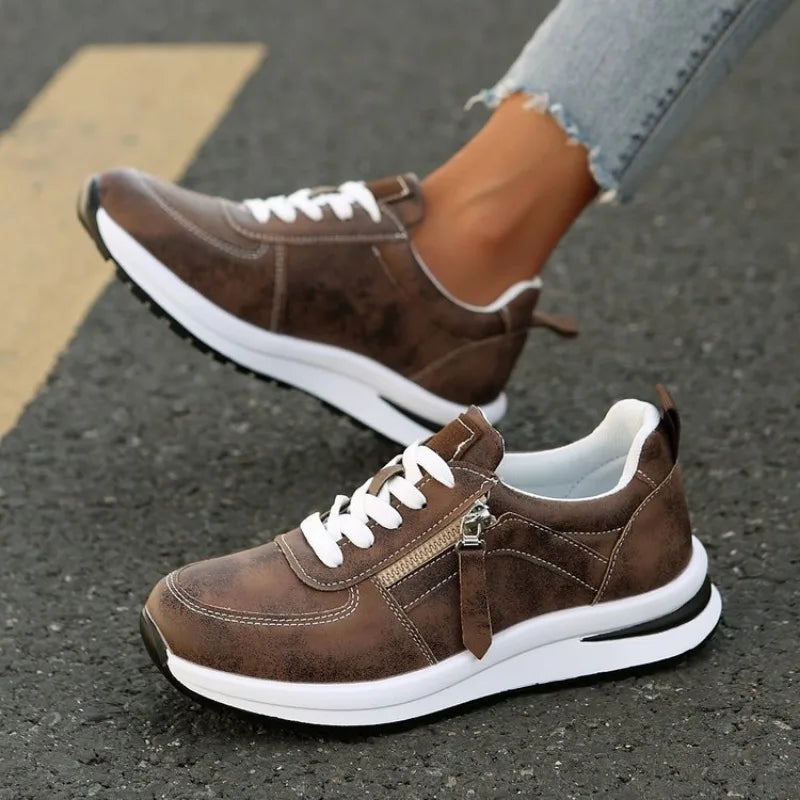 Brown zip-up comfort sneakers, lace-up front with metal zipper and white midsole