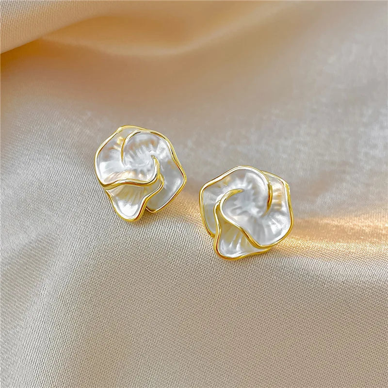Gold-tone pearl flower stud earrings, white petal design in profile