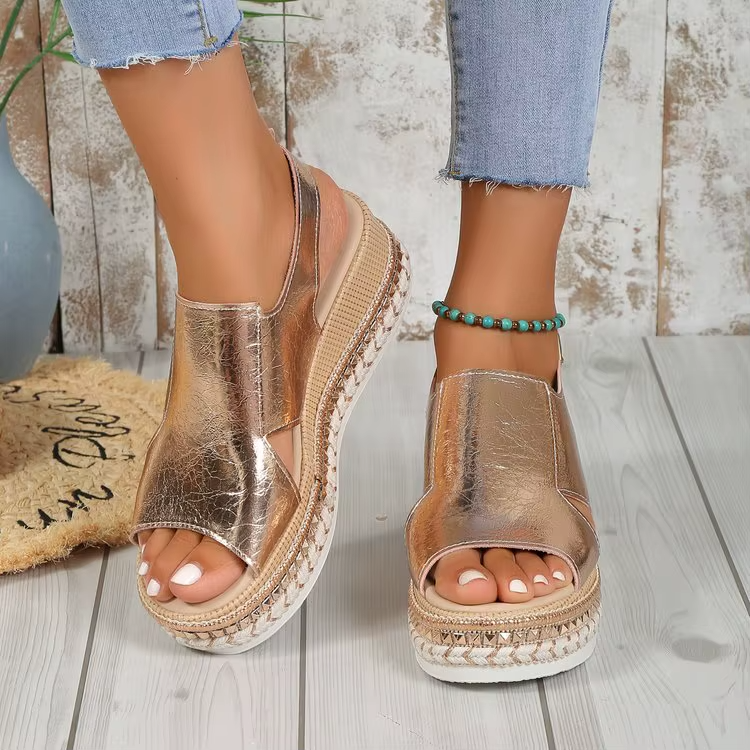 Pair of silver metallic open-toe platform sandals with ankle straps and braided trim sole