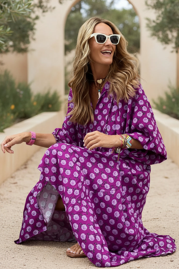Bohemian dress in purple with white floral print, flowing maxi length, wide sleeve style