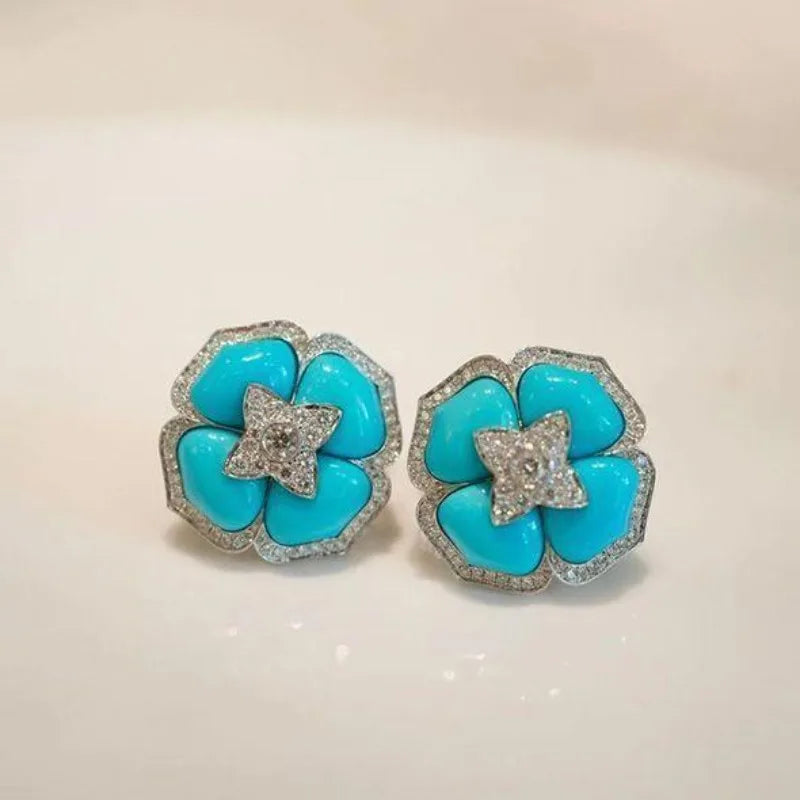 Turquoise flower stud earrings with silver-tone crystal center and halo edging