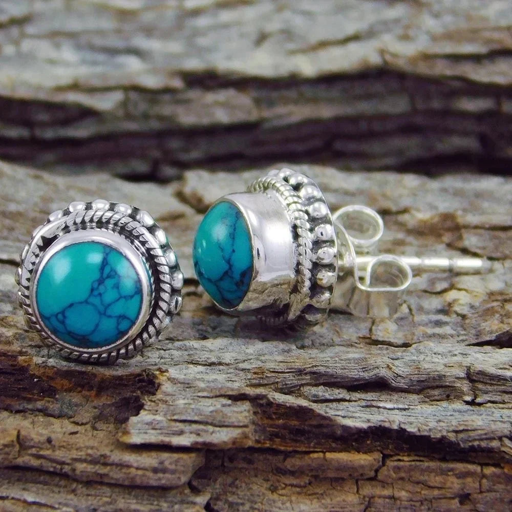 Turquoise stud earrings shown from the back with silver posts and capped backs