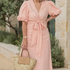 V-neck midi dress in soft pink with puff sleeves and tied waist.