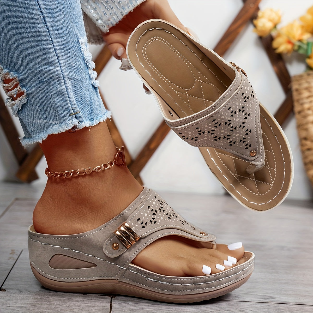Grey perforated slide sandals with buckle strap and tan stitched sole