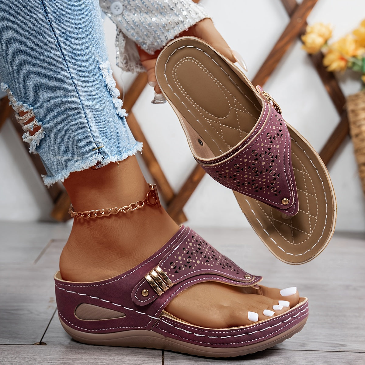 Burgundy perforated slide sandals with buckle strap and tan stitched sole